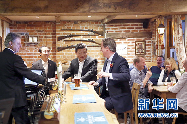 這是會(huì)晤結(jié)束后，習(xí)近平在卡梅倫陪同下乘車前往當(dāng)?shù)匦℃?zhèn)體驗(yàn)酒吧文化。新華社記者 鞠鵬 攝